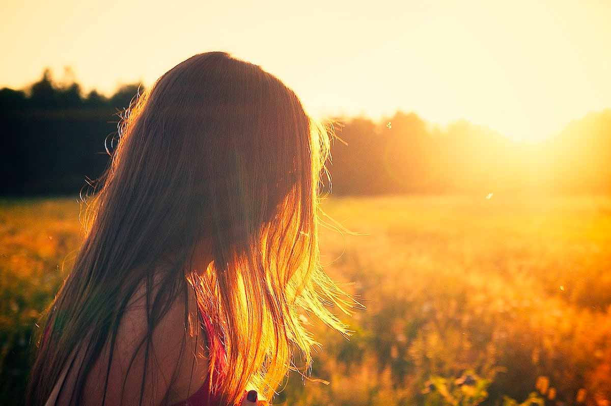 photo d'une femme dans une champs lumière du soleil